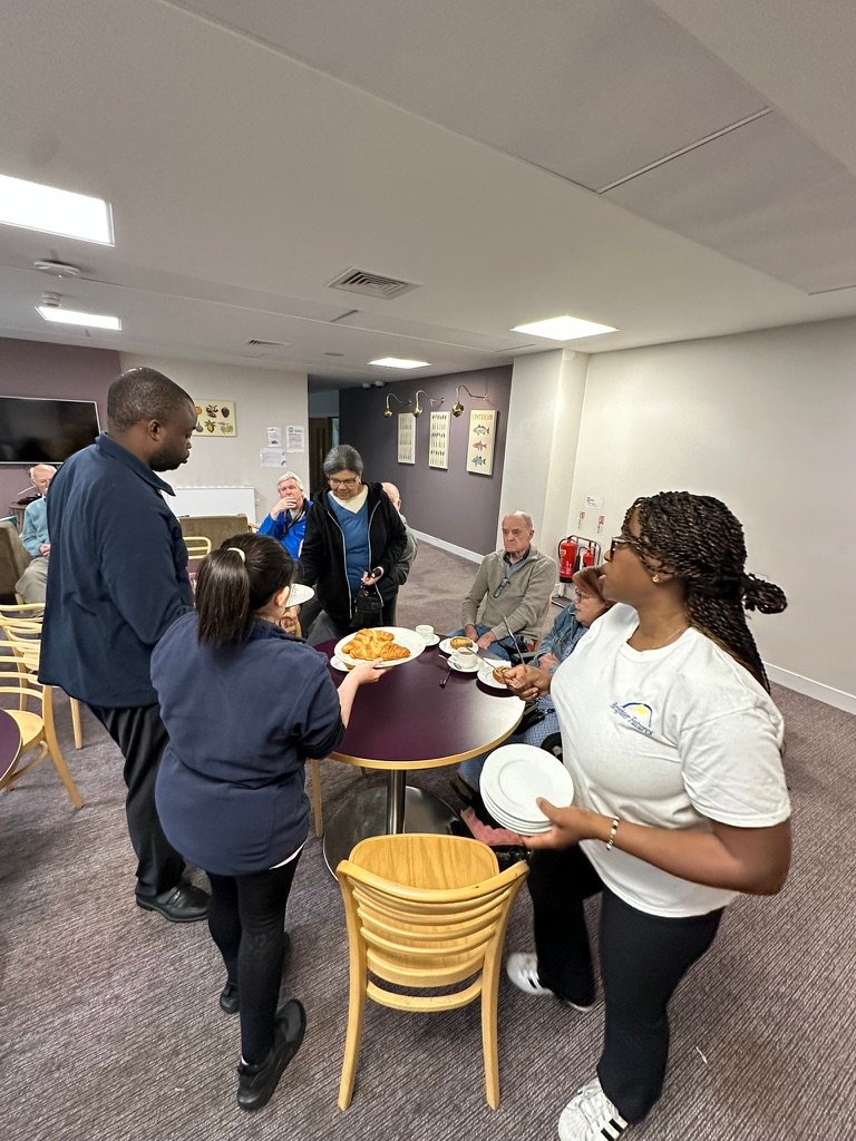 Learner serving food to customers in the café